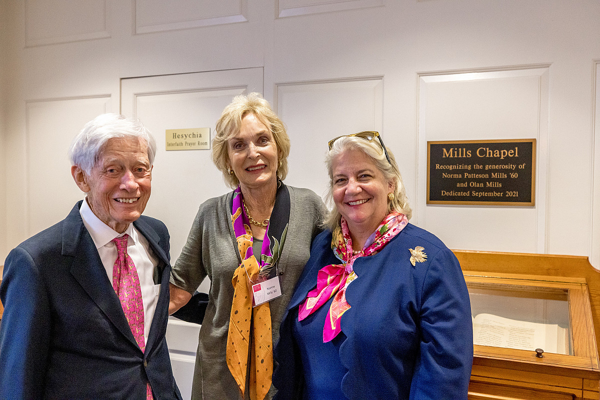 Three posing with dedication sign