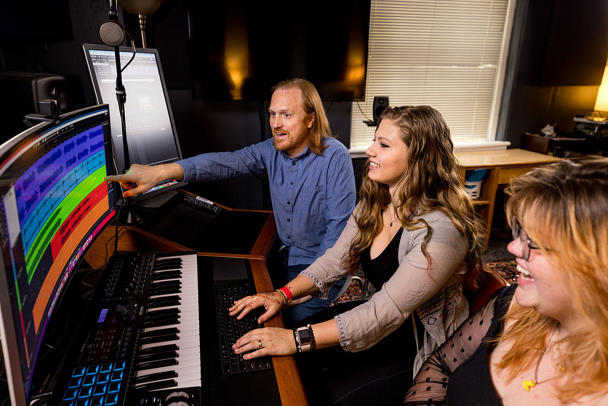 Music Professor Joshua Harris works with students in the multimedia production studio.