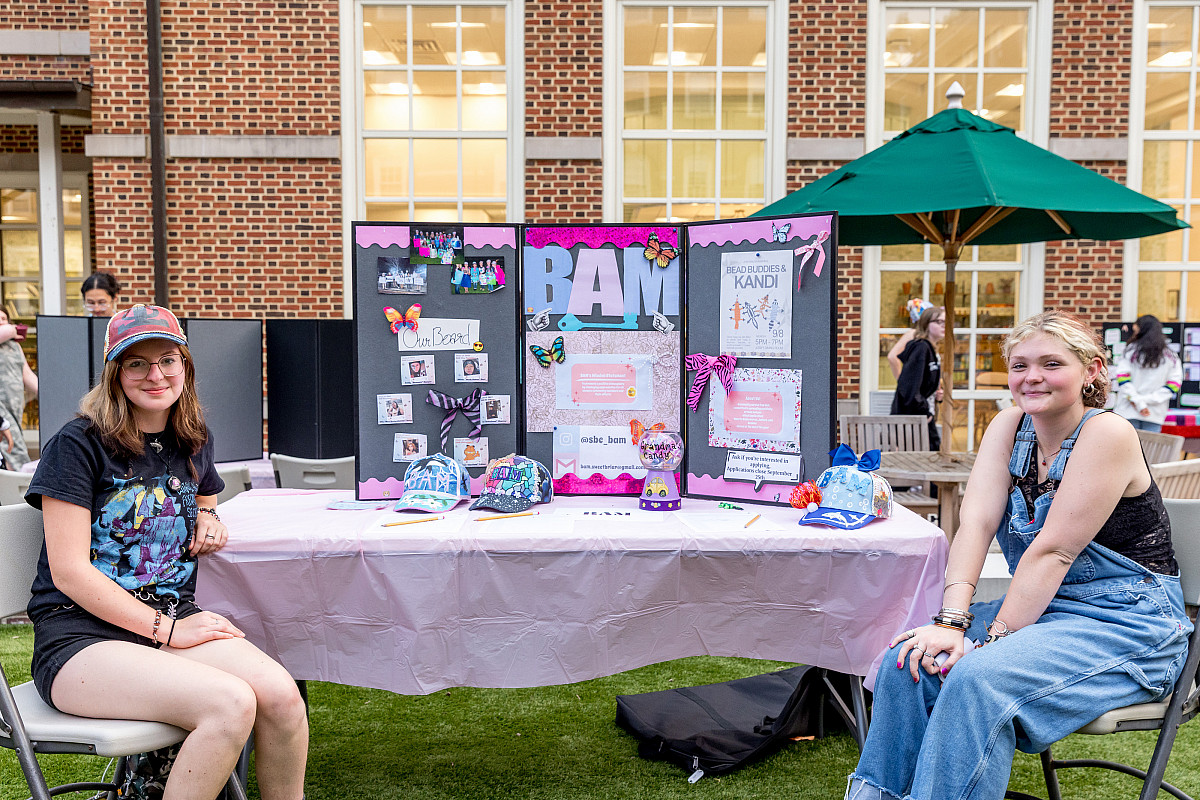Students sitting with poster