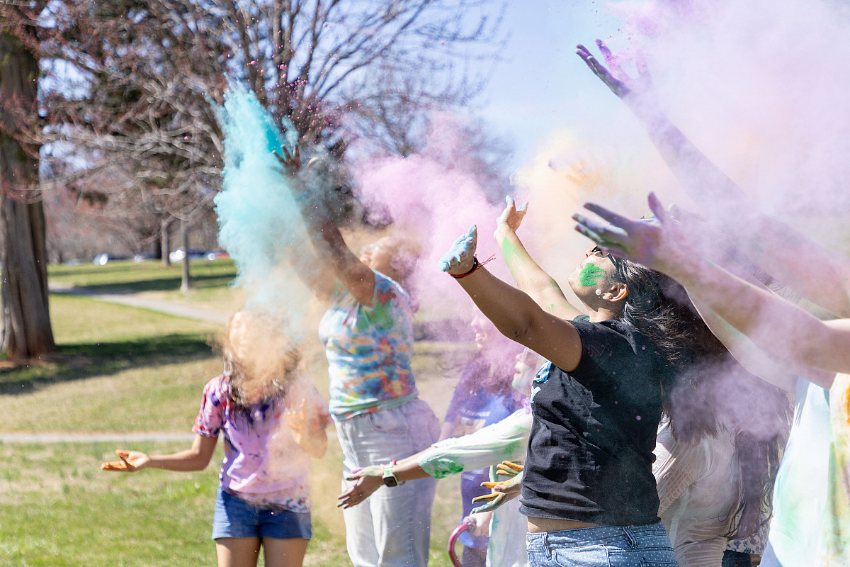 Students throw colored powder